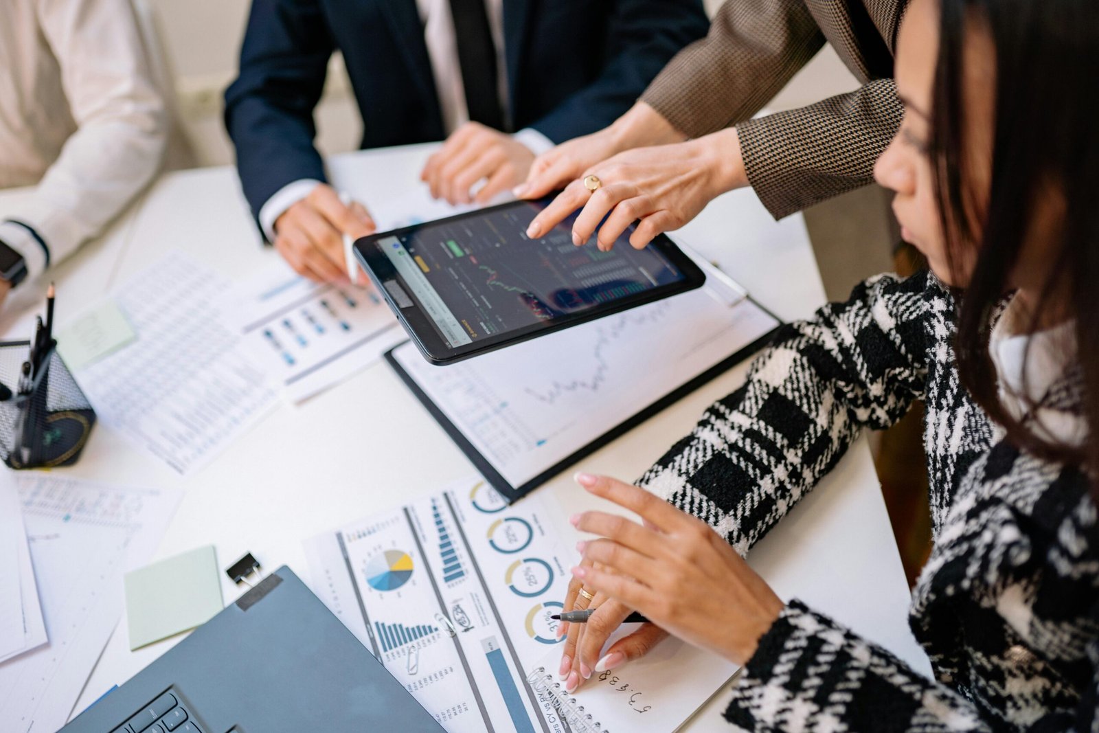 Business professionals reviewing analytics on a tablet during a meeting.